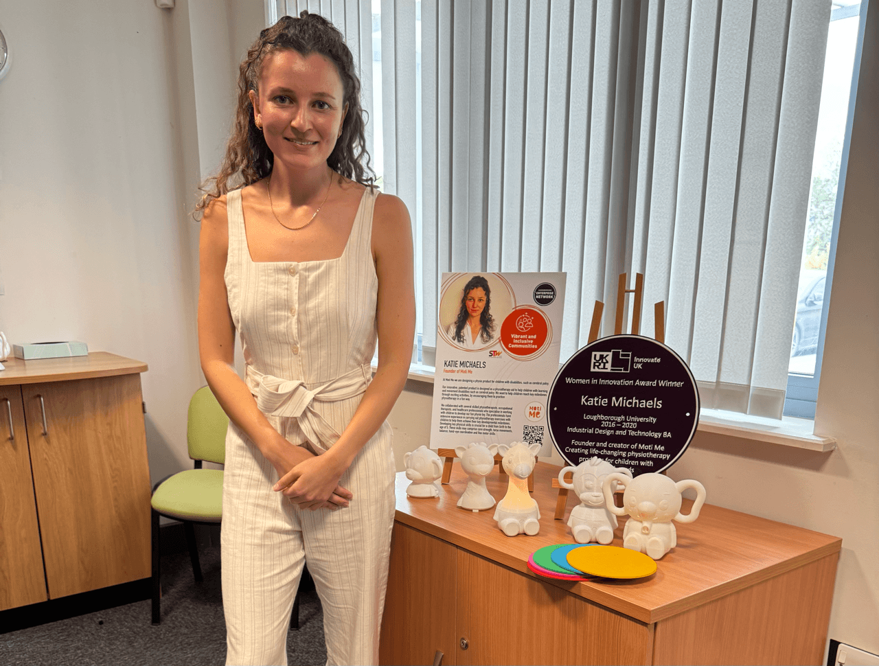 Moti Me 창업자 Katie Michaels가 사무실에서 Moti Me 장치와 함께 포즈를 취하고 있습니다.